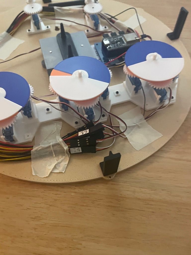 Le prototype de départ : servomoteurs, engrenages imprimés en 3D et câblage sur un fond en bois